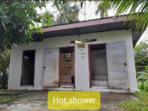 a small house with two doors and a hot shower at Nature Dormitory in Ban Donsôm Tai