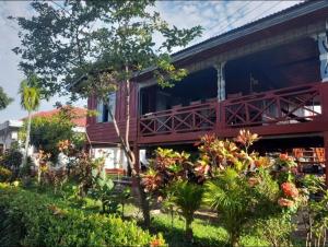a building with a balcony with trees and plants at Nature Dormitory in Ban Donsôm Tai