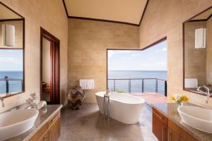 a bathroom with two sinks and a tub with a view at Four Seasons Resort Costa Rica at Peninsula Papagayo in Culebra
