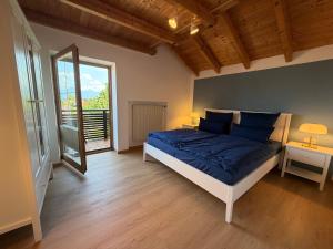 a bedroom with a bed with blue sheets and a window at Ferienwohnen beim Hirsch in Hopferau