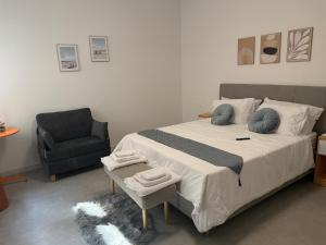 a bedroom with a large bed and a chair at Casa sissy in Chioggia