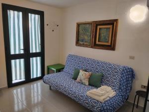 a blue couch in a room with a window at MAREVIGLIOSO Fronte Mare Sea Front in Magomadas