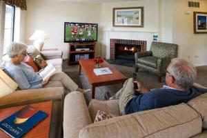 a group of people sitting in a living room watching tv at Brewster Green Resort in Brewster