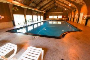 a large swimming pool with two white chairs in front of it at Brewster Green Resort in Brewster