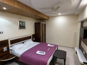 a bedroom with a bed with a purple blanket at Sunset View in Mahabaleshwar