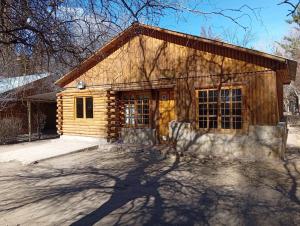 a small log house with a driveway in front of it at Cabañas Espacio Prana in Uspallata