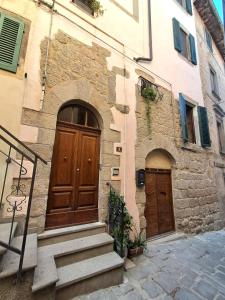ein Steingebäude mit zwei Holztüren und Treppe in der Unterkunft Nerucci 3 in Castel del Piano