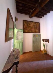 ein Zimmer mit einer grünen Tür und einem Gemälde an der Wand in der Unterkunft Nerucci 3 in Castel del Piano