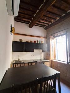 eine Küche mit Tisch, Spüle und Fenster in der Unterkunft Nerucci 3 in Castel del Piano