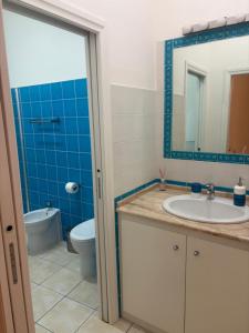 a bathroom with a sink and a toilet and a mirror at Casa Mare Teulada Sardegna in Teulada