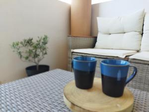 two blue cups sitting on a table in a room at La Terrasse des Voiliers in Frontignan