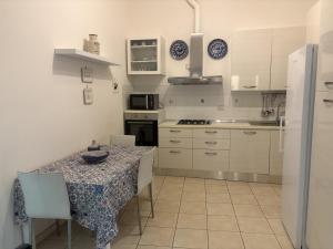 a kitchen with a table with chairs and a refrigerator at Casa Mare Teulada Sardegna in Teulada +9 photos