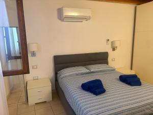 a bedroom with a bed with blue pillows on it at Casa Mare Teulada Sardegna in Teulada