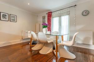 a dining room with a glass table and white chairs at Links Lodge - Blacklaws Steading in Anstruther