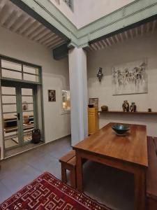 a living room with a wooden table and a pillar at La Maison des Amis in Fez