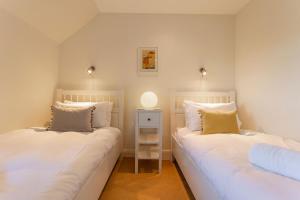 two twin beds in a room with a side table at Links Lodge - Blacklaws Steading in Anstruther