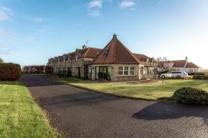 a large house on a street with a driveway at Links Lodge - Blacklaws Steading in Anstruther