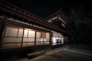 a building at night with a light in the windows at 福渡邸 in Narita +14 photos