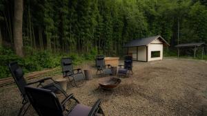 a group of chairs and a cabin in the woods at 福渡邸 in Narita