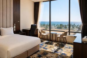 a hotel room with a bed and a large window at المهاجر للشقق المخدومة بالكورنيش in Jeddah