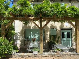 a garden with a wooden pergola with a table and chairs at Auberge du Fel in Le Fel