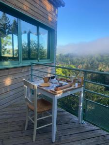 a table and chair on a balcony with a view at Auberge du Fel in Le Fel