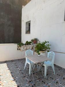 a wooden table and two chairs on a patio at Lemjid house in Kelibia