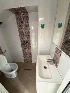 a white bathroom with a toilet and a sink at Lemjid house in Kelibia +4 photos