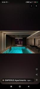 a large swimming pool in a hotel room at Emperus Taša spa apartman in Veliko Gradište