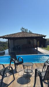 a patio with chairs and a table next to a pool at Cabanas Belvedere in Lauro Müller
