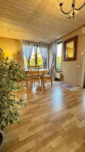 a dining room with a table and chairs on a wooden floor at На Видземском взморье Калнгале in Kalngale