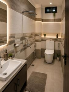a bathroom with a white toilet and a sink at Hotel Embassy in Saharsa