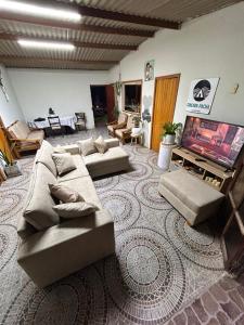 a living room with couches and a flat screen tv at Cabaña de campo privada con piscina in Casa Blanca Hacienda