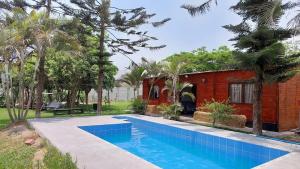 a swimming pool in front of a house at Cabaña de campo privada con piscina in Casa Blanca Hacienda
