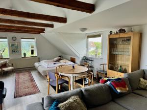 a living room with a couch and a table and a bed at Hostel Agger Vandrerhjem in Agger