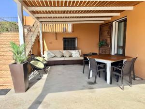a patio with a table and chairs and a couch at Casa Altoliva in Marsala +29 photos
