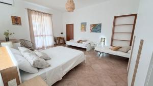 a bedroom with two beds and a living room at Casa Altoliva in Marsala