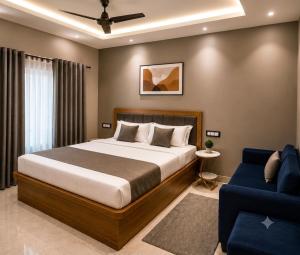 a bedroom with a bed and a blue couch at Hotel Embassy in Saharsa
