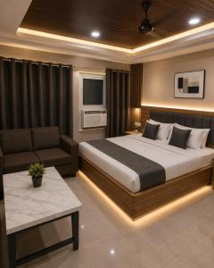 a bedroom with a large bed and a couch at Hotel Embassy in Saharsa
