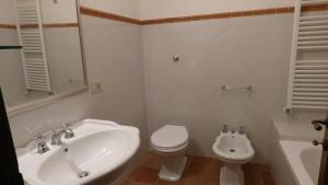a white bathroom with a sink and a toilet at Le Ginestre in San Gimignano