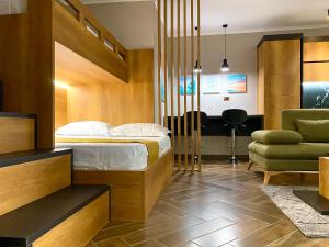 a bedroom with a bed and a couch and a chair at EKA Luxury Beachfront Apartments in Vlorë