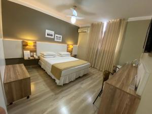 a bedroom with a bed and a ceiling at JB Palace Hotel in Divinópolis