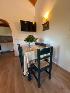 a dining room table with a vase of flowers on it at Elia House in Skopelos Town