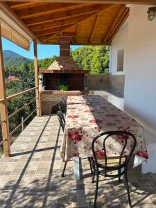 a table and chairs on a patio with a fireplace at Elia House in Skopelos Town +5 photos