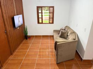 a living room with a couch on a tiled floor at Cabanas Belvedere in Lauro Müller