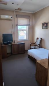 a hotel room with a bed and a television at Comfort Continent in Oktyabrʼ