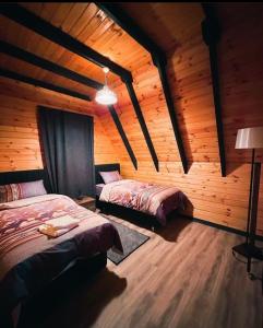 a bedroom with two beds in a wooden cabin at Dilek Alagöz in Sapanca +8 photos