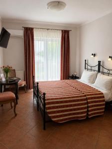 a bedroom with a large bed with a large window at Villa Toscana in Hajdúszoboszló
