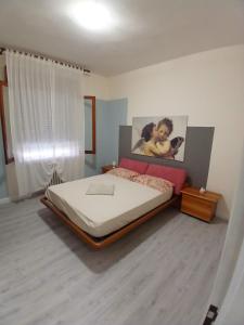 a bedroom with a bed and a painting on the wall at B&B Angelo Azzurro in Carpi