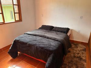 a bedroom with a bed with a gray comforter at Cabanas Belvedere in Lauro Müller